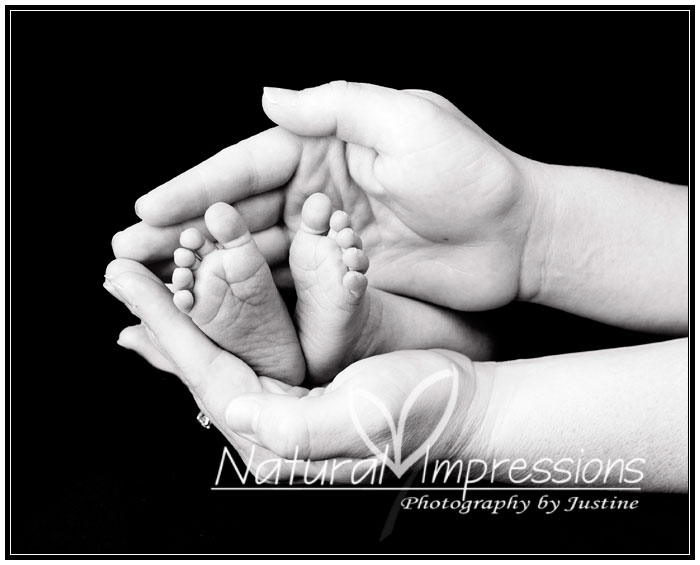 Newborn baby feet with parent's hands newborn feet photo