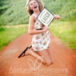 Senior girl jumping senior girl on gravel road