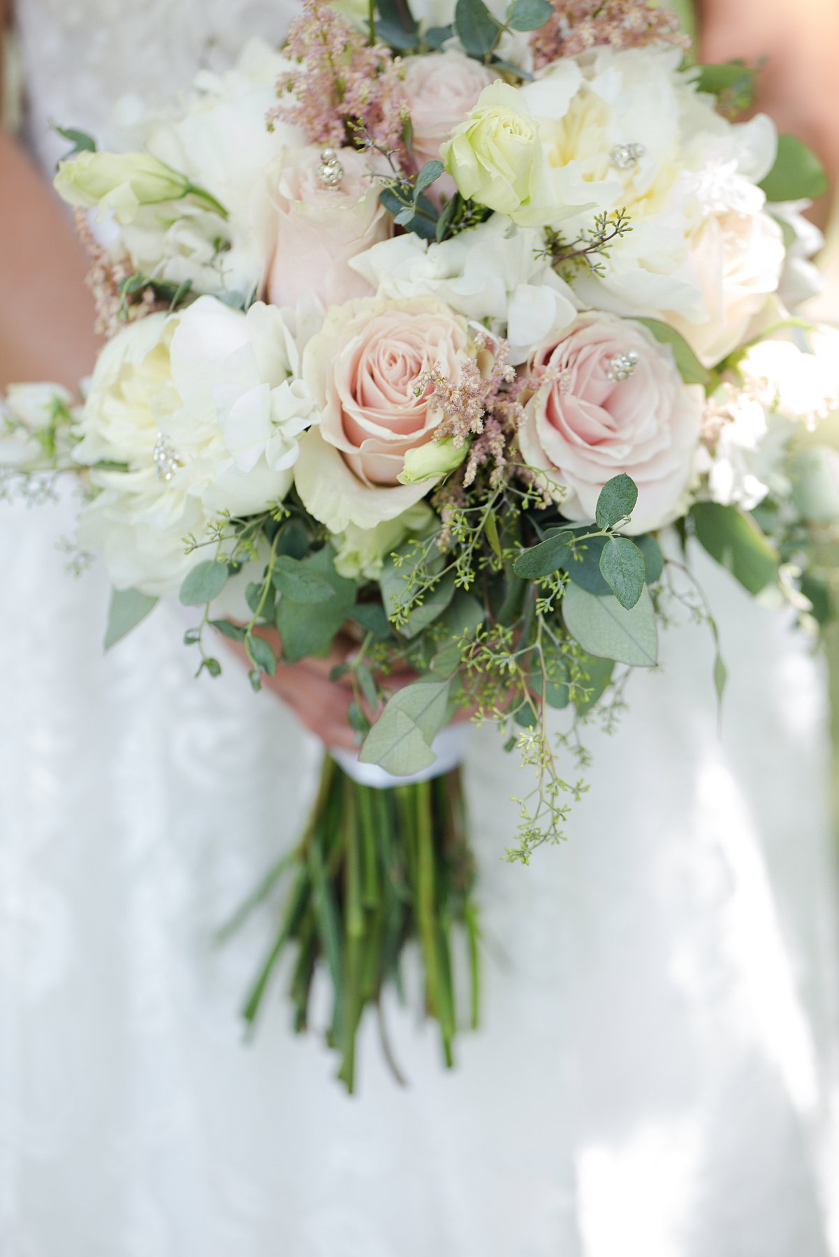 detail photo of wedding bouquet in blush pink and sage green.  Photo by Bismarck wedding photographer Photography by Justine