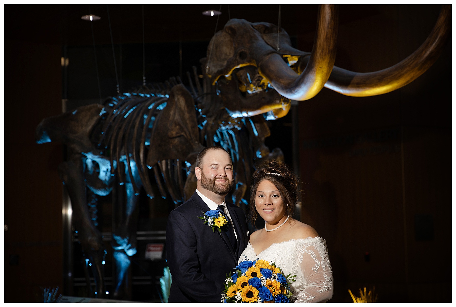 Bride and Groom with Mammoth lit in background at the Bismarck Heritage center Museum
