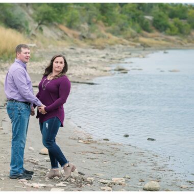 Couple pose by the Missouri River for engagement pictures