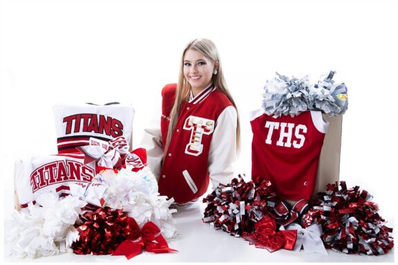 Senior Girl posing with her cheerleading uniforms and moms