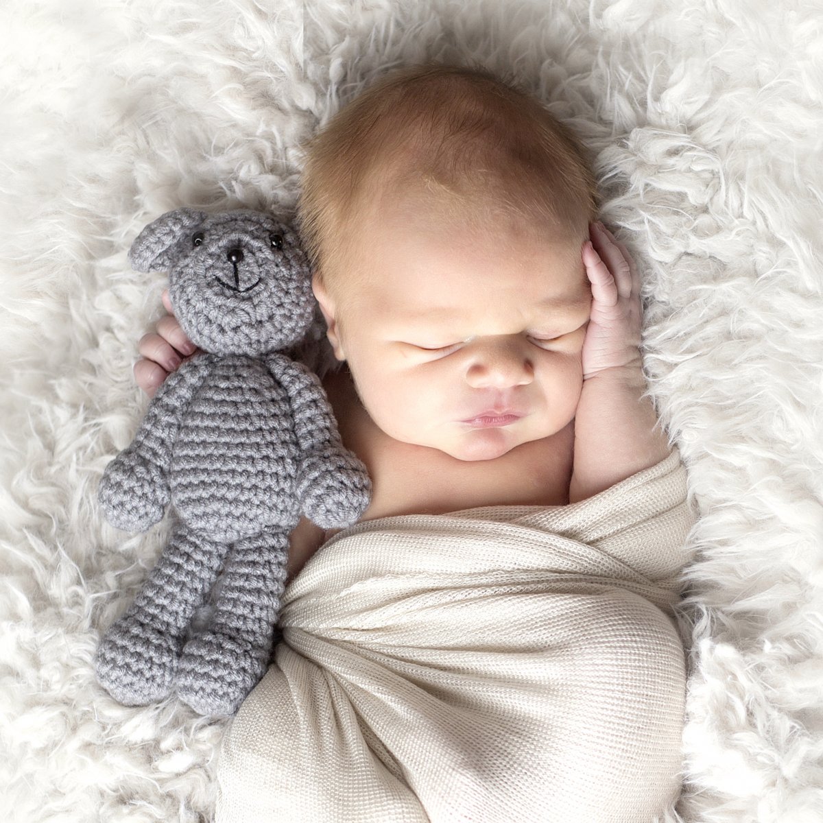 Newborn baby in wrap and mini teddy bear.  Photo by Natural Impressions Photography by Justine photographer in Bismarck ND