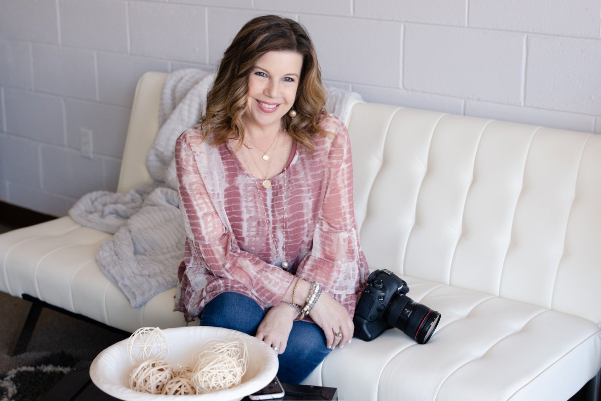 Justine at studio sitting on sofa.   She is a wedding photographer in Bismarck ND with studio in Hazen